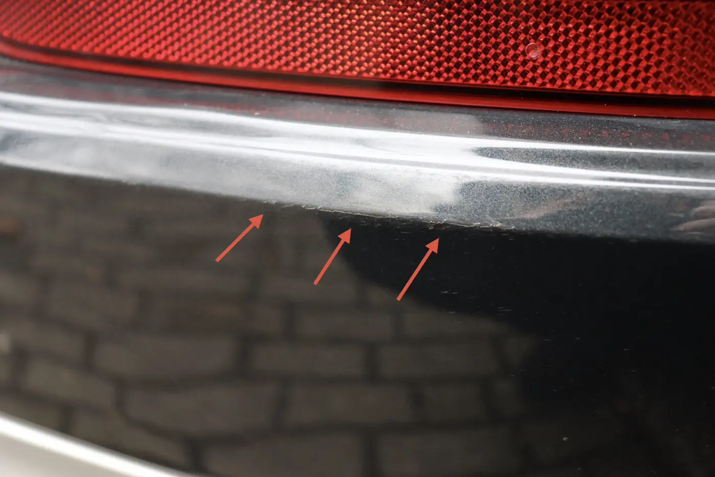 Detailaufnahme von Kratzspuren am hinteren Stoßfänger des Volvo XC90